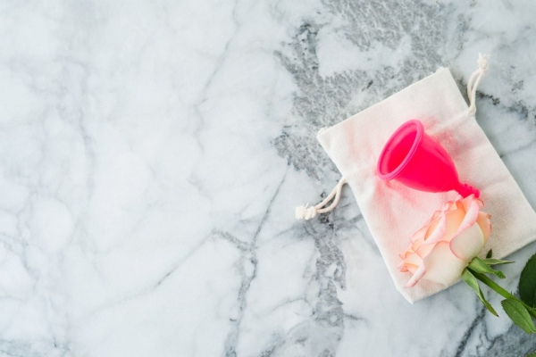 pink-menstrual-cup-with-cotton-bag-on-marble-table
